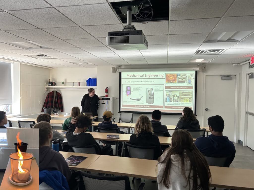 Echo presenting to high school students with flame demonstration