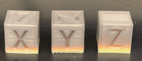 Three multicolor 3D-printed blocks reading X, Y, and Z